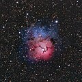 Trīskāršais miglājs Strēlnieka zvaigznājā dabiskajās krāsās. Sastāv vienlaikus no dažādu tipu miglājiem, kur tumšais miglājs ir melnās līnijas.