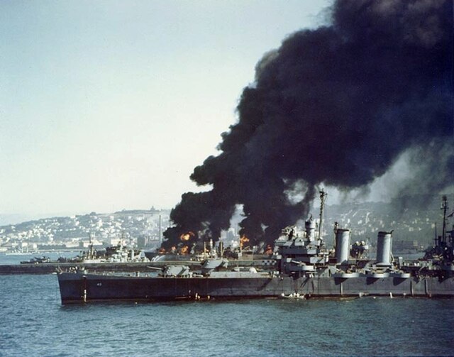 USS Savannah in Algiers, 16 July 1943, near burning Liberty ships.