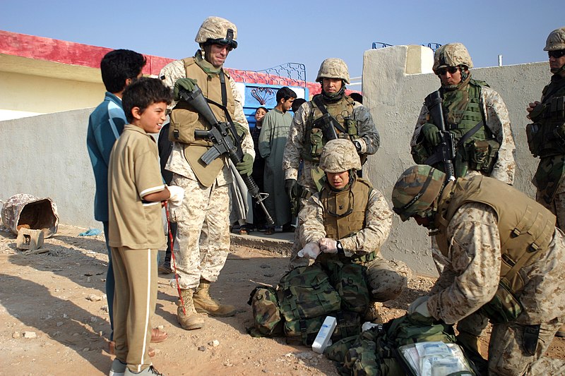 File:US Navy 041103-M-0036Y-015 Hospital Corpsman 2nd Class Raoke, left, and Hospital Corpsman 3rd Class Bolton, help to clean and bandage an Iraqi boy's right hand.jpg