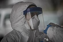 A medical worker wearing a face shield adjunct to other personal protective equipment at a COVID-19 testing site 200323-Z-NI803-0964.jpg