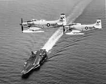 A-1H Skyraiders of VA-145 over USS Constellation. A-1H Skyraiders of VA-145 in flight over USS Constellation (CVA-64), circa 1964 (NNAM.1996.253.2786).jpg