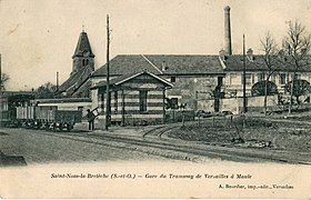 De tram in Saint-Nom-la-Bretèche Let op het kleine gebouwtje dat dienst doet als station.  Het treinstel is een gemengde trein, met een personenwagen in de voorste en goederenwagons in de staart.