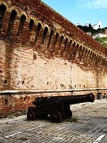 A cannon situated near the Arch of Trajan, with the Ancona Cathedral in the background