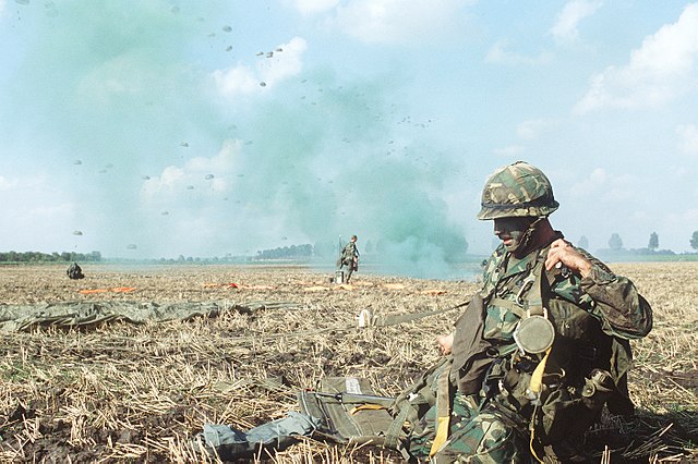 U.S. Army paratroopers landing in a field in West Germany during Exercise Reforger 1984, a Cold War-era NATO military exercise used to prepare for pot