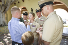 80427-N-ZZ368-002 SAN DIEGO (April. 27, 2018) Family and friends place senior chief anchors on the uniform of Senior Chief Naval Aircrewmen Erica Gibson, during a promotion ceremony at Naval Base Coronado, April 27. Gibson is the first ever female, search and rescue (SAR) swimmer to promote to the rank of senior chief petty officer. Gibson-Promotion Navy-SAR-Swimmer.webp