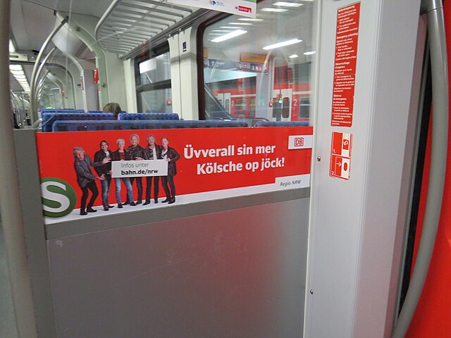Colognian dialect on a sign on an S-Bahn train. Translation: "Everywhere, we Cologners are on the move!"