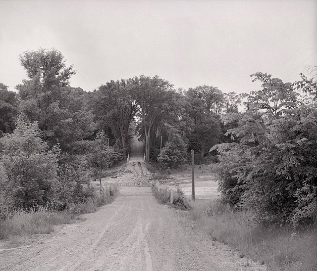 Looking north on Kipling Avenue in 1955 towards the bridge over the west branch of the Humber River after it was washed out by Hurricane Hazel.
