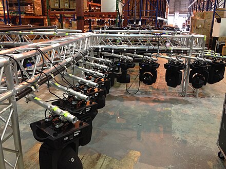 Moving lights hanging on a truss, ready for rigging and chain motors.