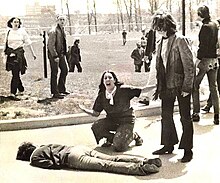 Vecchio, photographed by John Filo kneeling over the body of Jeffrey Miller. May 4, 1970. In this widely circulated version of the photo, a fencepost behind Vecchio has been airbrushed out. Mary Ann Vecchio Kent State May 4 1970 John Filo Photograph.jpg
