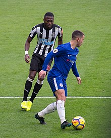 Mbemba (left) and Chelsea's Eden Hazard in 2017 Mbemba and Hazard.jpg