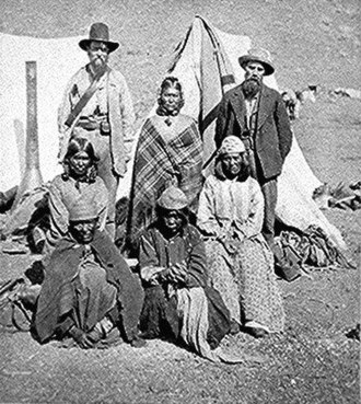 L to R, standing: US Indian agent, Winema (Tobey) Riddle, a Modoc; and her husband Frank Riddle, with four Modoc women sitting in the front two rows. 