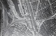Luchtfoto van het Rangeerterrein De Rietlanden (links), met in het midden de ronde locomotiefloods. Rechts de spoorlijn naar Station Muiderpoort; omstreeks 1930.