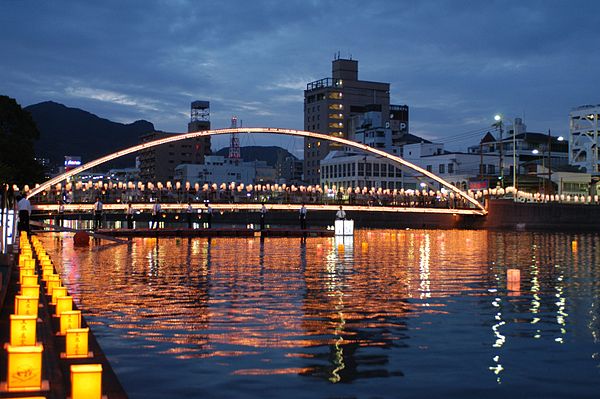 Participants place candlelit lanterns in the Sasebo River during Obon.