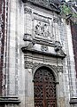 Side entrance of church with stone figures of Saints Dominic and Francis holding up the Church of Letran