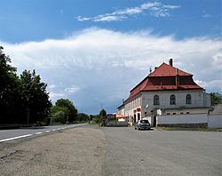 Historická budova restaurace a autobusová zastávka Sobáčov u hlavní silnice