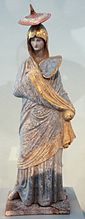 Une « Dame en bleu »[77]. Statuette de Tanagra, 335-300. Terre cuite peinte et dorée, H. 34 cm. Altes Museum