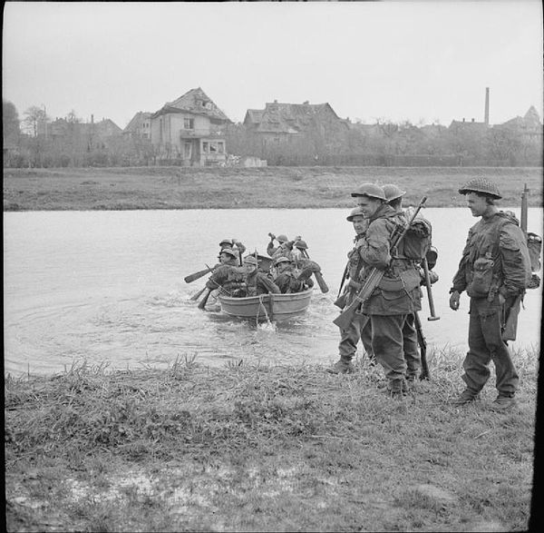 Men of the 7th Battalion, Cameronians (Scottish Rifles) use a small boat to cross a canal in the town of Rheine, Germany, 3 April 1945.