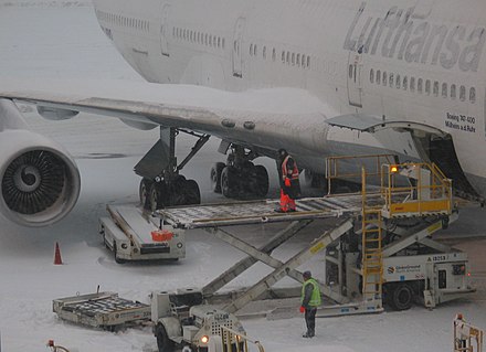 Loading luggage onto a Boeing 747 at Boston Logan Airport, during snow