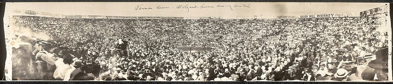 Panoramic photo of Wolgast–Rivers boxing match, July 4, 1912: "There are thousands in Los Angeles who saw Ad Wolgast fight Joe Rivers in a never-to-be-forgotten battle at Vernon about nine years ago when both men were knocked out in the 13th round and Wolgast staggered to his feet first and was awarded the decision."[31] The words "Vernon Arena" were written on the print but this is actually the Vernon baseball field—Jack Doyle "used the ballpark for the really big fights (Ad Wolgast was very popular) because he could cram more bodies in more seats".[32]
