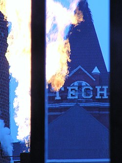 Georgia Tech's steam whistle (the grey smoke on the bottom-left) with a fuel burn-off and Tech Tower in the background. Whistle Tech Tower.jpg