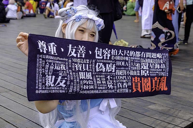 File:A Taiwanese female cosplayer showing a banner of keywords about nude or partially nude cosplay in Taiwan 20201107.jpg