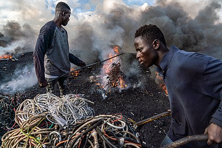 Workers recovering metals from e-waste in Agbogbloshie, a e-waste recovery site in Ghana. Exported e-waste is frequently processed in situations that are unhealthy for the workers, where they are exposed to toxics.