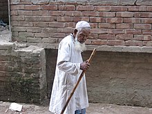 An elderly Bangladeshi man with a walking stick An Old Man by Rezowan.jpg