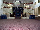 פנים בית הכנסת הקראי במושב מצליח. הוא אינו מכיל כיסאות או ספסלים, ובמקומם יש שטיחים, שעליהם עומדים, כורעים, יושבים או משתחווים המתפללים