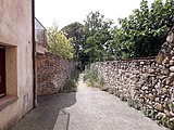 Camí Ral a Argelaguer. El tram marcat amb una placa informativa passa per sota d'una casa, amb una volta.