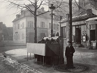 Urinoir (Vespasienne) en ardoise à trois stalles, chaussée du Maine, à Paris, photographié par Charles Marville vers 1865 (bibliothèque d'État du Victoria). (définition réelle 5 242 × 3 939)