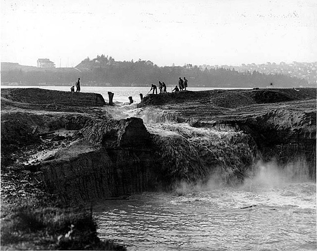 Cutting the cofferdam at Montlake in 1913, draining Lake Washington over the next three months until it was level with Lake Union