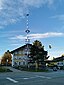 Maibaum am Kirchplatz, oben eine Adler-Skulptur