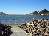 Waikouaiti River estuary at Karitane; fishing wharf and channel to the Pacific Ocean at right, Matanaka headland at left background. Karitane port.JPG