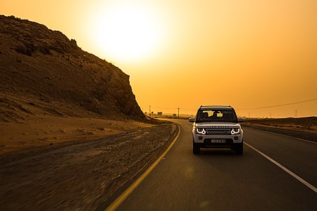A Land Rover driven through the middle east desert at sunset