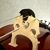 A rubber two-hole Tourte mute on the bridge of a cello Mute on cello.jpg