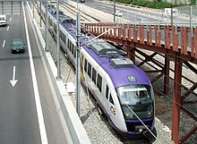 An OSE class 460 train in the median strip of Attiki Odos, bound for Athens Airport.