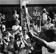 Olympic torch at the University of Texas at Arlington, 1984 Olympic Torch being carried in front of crowd at University of Texas at Arlington's Hereford Student Center (10010571).jpg
