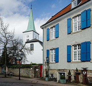 Street in Mülheim an der Ruhr with village church and a historic building