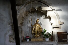 Fotografia de uma estatueta dourada, com inscrição em basco: Jondoni Martine.