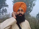 Ung sikh med turban og mobiltelefon.