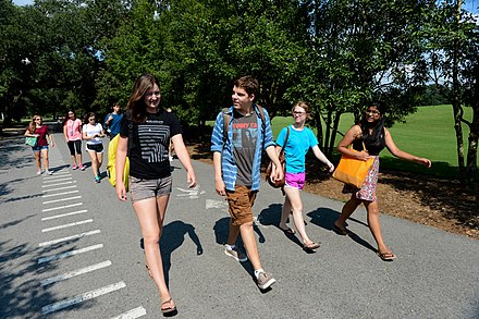 Students of a U.S. university do an outdoor class, where they discuss topics while walking.