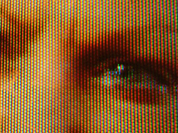 Close-up of a trichromatic in-line shadow mask CRT display, which creates most visible colors through combinations and different levels of the three p