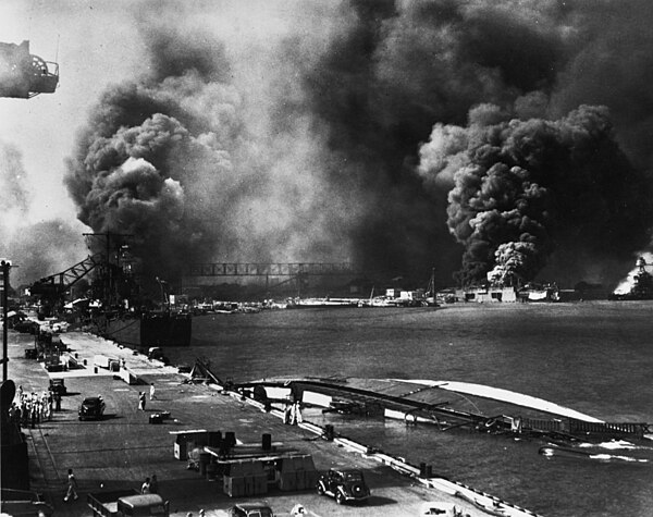 Helena (center left) at 1010 dock after the attack; Oglala has been towed astern where she capsized. Smoke clouds from the burning destroyers Cassin a