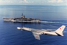 A Tu-16 Badger C of the AV-MF overflies Ranger during her 1989 WESTPAC cruise