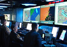 Joint Operations Center watch standers aboard the command ship USS Mount Whitney in the year 2005. US Navy 040616-N-3725R-009 Joint Operations Center watch standers review the latest battle assessment.jpg