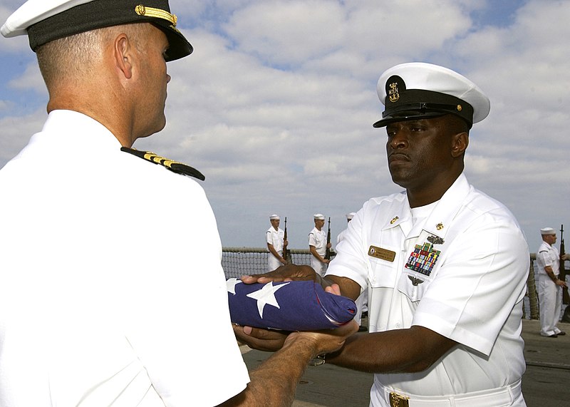 File:US Navy 061110-N-3285B-065 The Command Master Chief Billy Hill, assigned to the Oliver Hazard Perry-class frigate USS Stephen W. Groves (FFG 29) hands a flag to the ship's Commanding Officer, Cmdr. Jon Kreitz, during a burial a.jpg