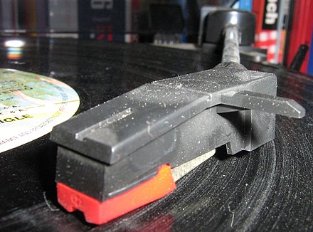 A dusty/scratched vinyl record being played. The dust settles into the grooves.