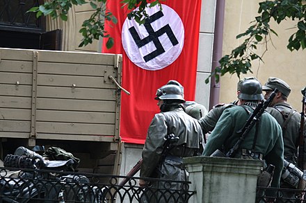 Wehrmacht reenactors near a flag of Nazi Germany during a reenactment of the Warsaw Uprising in Mokotów