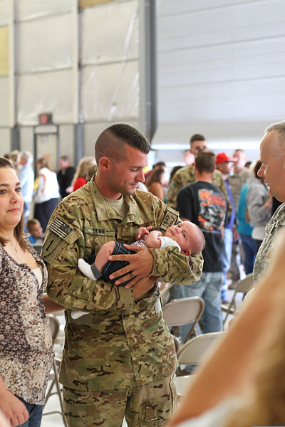 File:A U.S. Soldier with Golf Company, 2nd Battalion, 135th Aviation Regiment, Kansas Army National Guard holds his child during a homecoming ceremony Sept 140907-Z-VX744-755.jpg