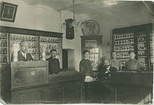 Antanas Vienuolis (first on left) in a pharmacy that he owned in Anykščiai
